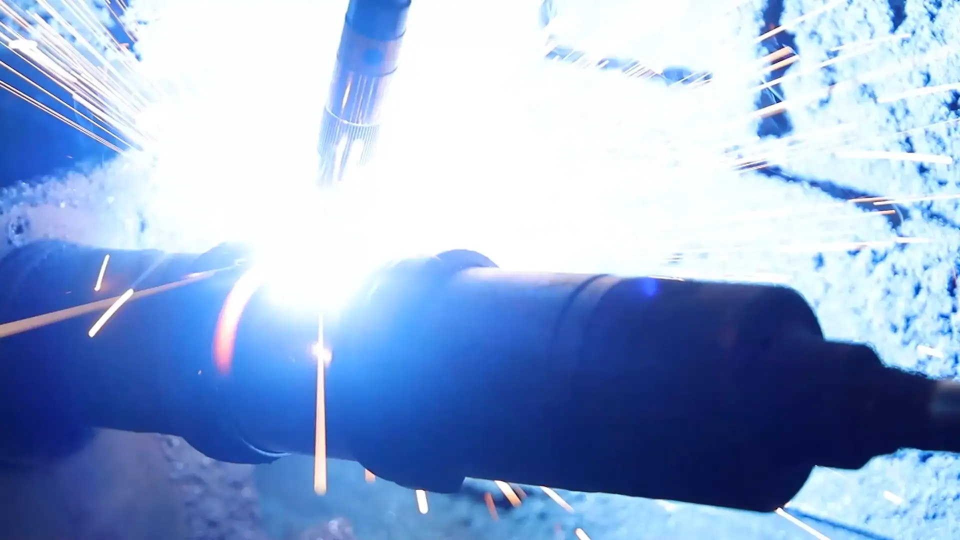 Welding process with sparks and bright light, showcasing industrial metalwork and craftsmanship. The image highlights the intense heat and precision involved in welding, emphasizing quality and techni.