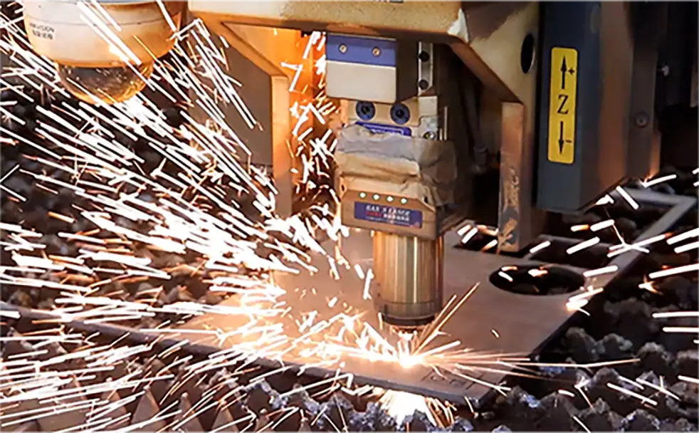 Industrial metal cutting with sparks and machinery.