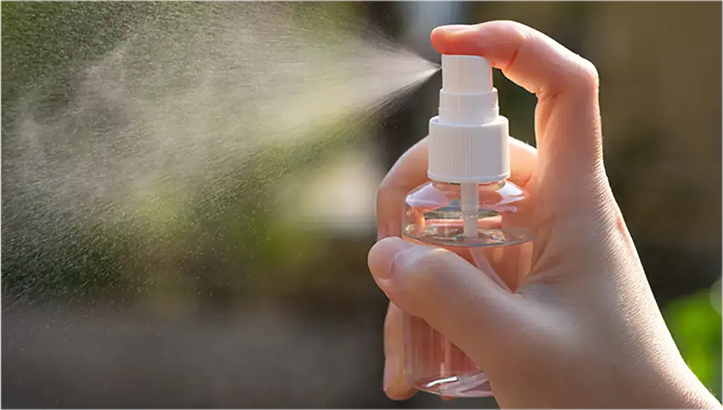 Hand holding a spray bottle releasing a fine mist, demonstrating advanced precision frequency control technology for energy efficiency.