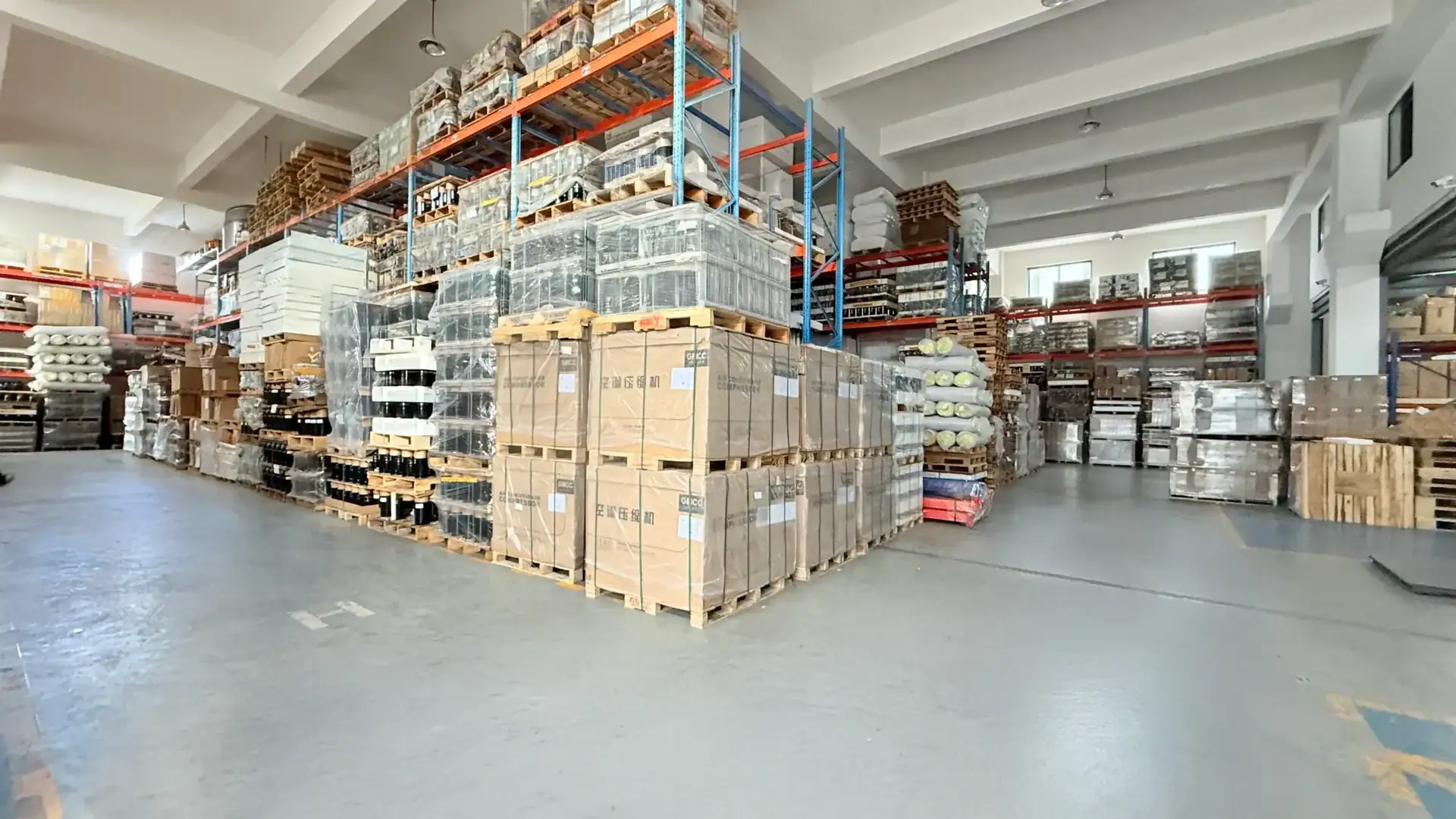 A spacious warehouse filled with pallets, boxes, and packaging materials, optimized for eCommerce and WooCommerce app logistics solutions.