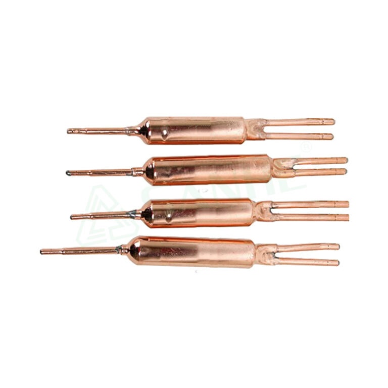 Four copper filter drier components used in HVAC systems, showcasing their cylindrical shape and two protruding tubes for refrigerant flow.